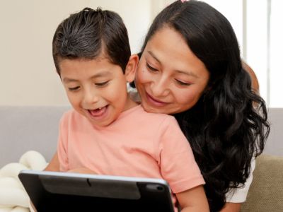 Mom hugs son who is on a tablet, getting close can help with screen time tantrums