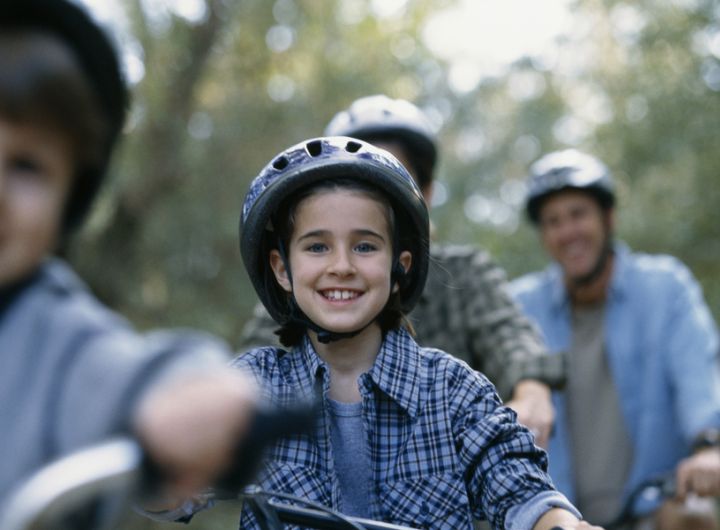 family riding bicycles through nature scene