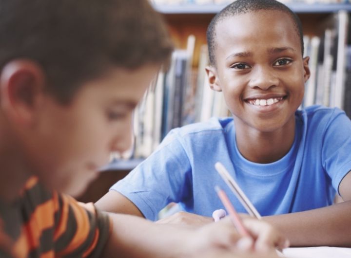 two boys doing schoolwork in the library